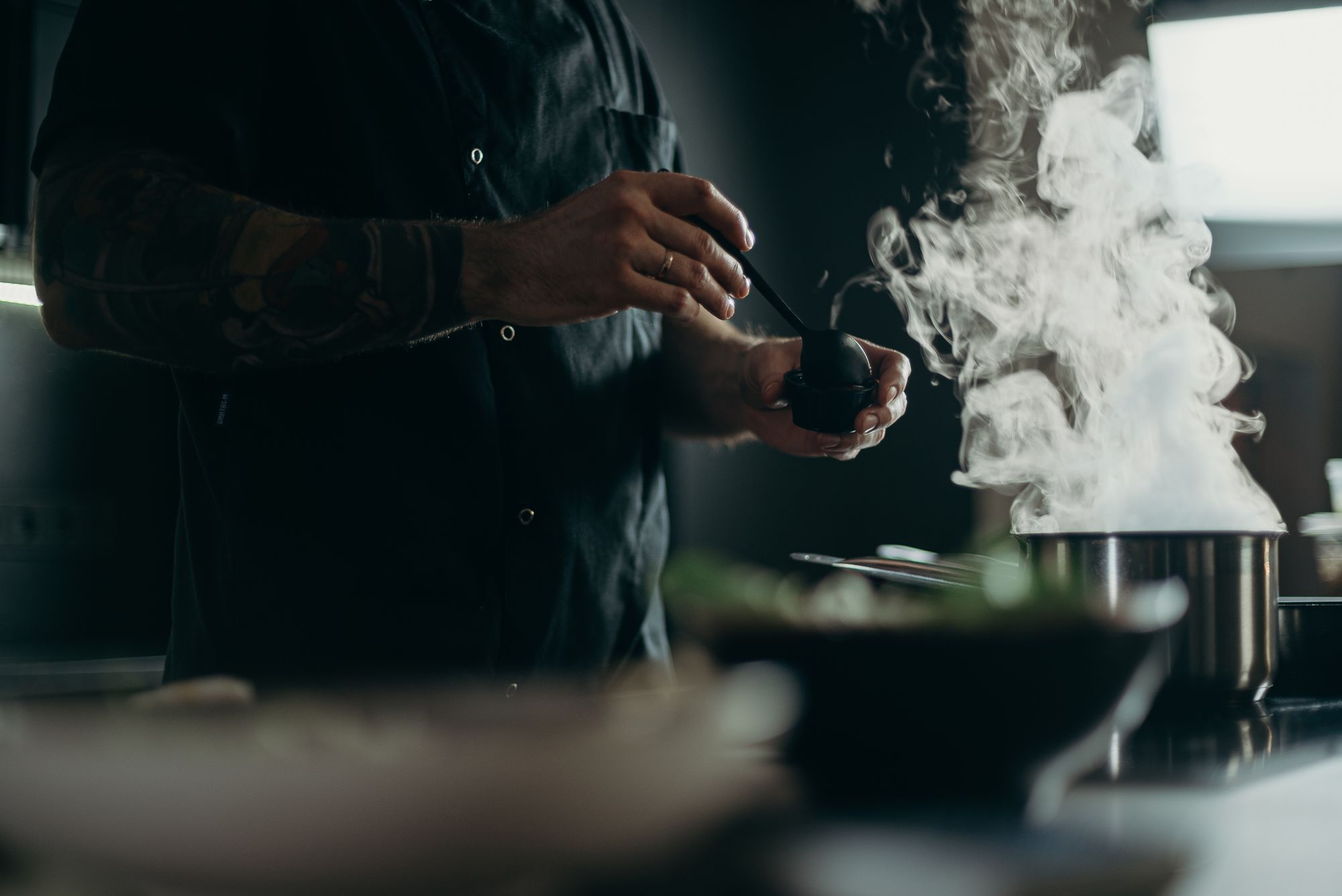 Chef working beside a steaming stainless steel pot