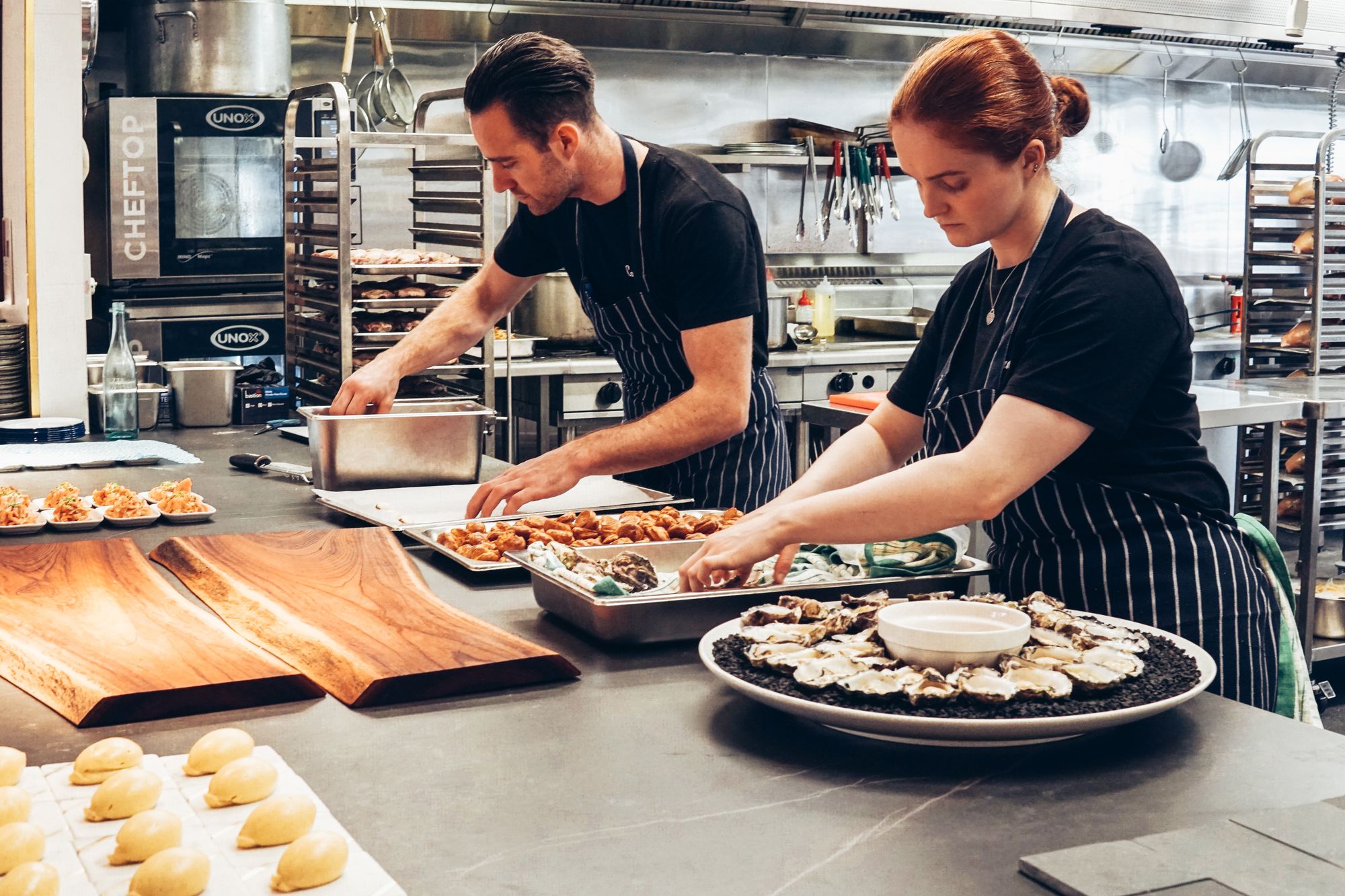 Chefs working at stainless steel stations in a commercial kitchen